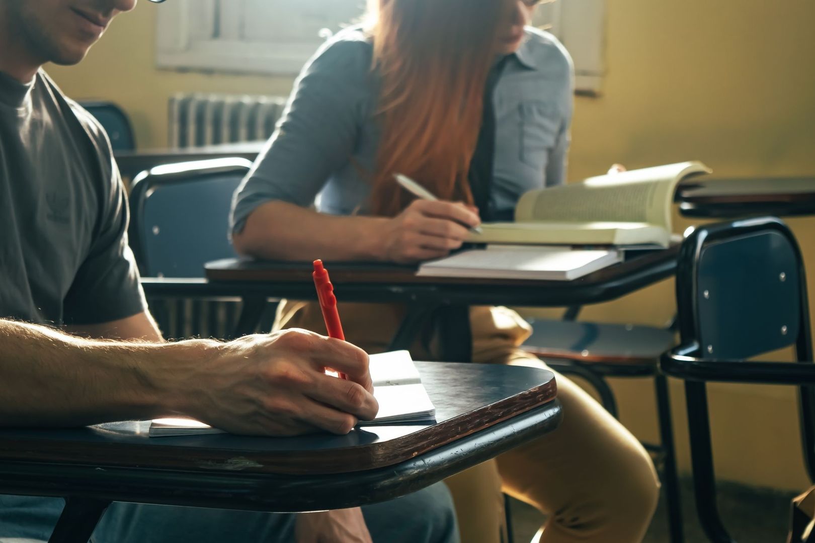 Elever skriver i anteckningsböcker under en lektion i klassrummet